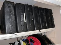 Seven black zip CD binders lined up on a shelf