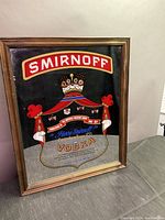 Smirnoff Vodka bar mirror with decorative crest and bold logo on black background.