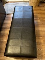 Top view of the bench showing black leather upholstery with stitched section details