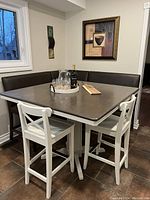 Corner bench seating, square table, and two white chairs from front view