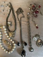 Overview photo showing multiple costume jewelry pieces including necklaces, earrings, and bracelets arranged on a table.