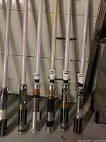 Close-up of six lightsaber hilts and blades