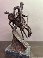 Right-side view of the bronze sculpture showing horse descending rocky slope