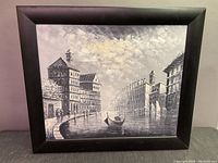 Grayscale cityscape canvas painting with gondola and buildings, framed in simple black wood frame.