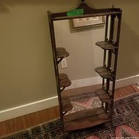 Front view of the antique mirror showing the vertical rectangular mirror and six small attached shelves (three on each side) plus a wider bottom shelf on the wooden frame.