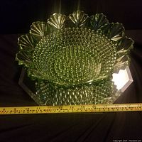 Set of green vintage Imperial Glass bowl and plate with hobnail textured interior and fan-shaped scalloped edges, measuring about 12 inches wide.