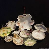 Photo showing a collection of 10 vintage decorative china pieces with various floral patterns on a dark background.