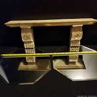 Full view of the small wall shelf showing the top rectangular shelf supported by two corbel brackets with carved leaf and scalloped detail.