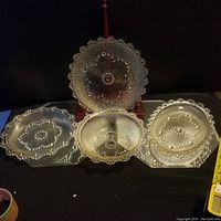 Five vintage Masserini Barocco glass dishes arranged together on black background showcasing varying shapes and intricate bubble patterns.