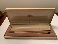 Vintage Cross pen in its original fabric-lined case with handling wear visible, leather protective sleeve included