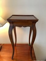 Front angle view of the Ethan Allen solid wood accent table showing tray top and curved legs with dark finish.