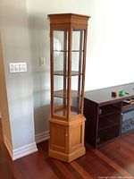 Full front and side view of the vintage handcrafted wood curio cabinet showing hexagonal shape, glass paneling, and wood finish.