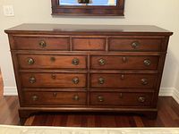 Front view of dresser showing nine drawers and brass hardware