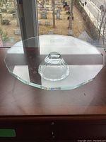 Clear crystal cake stand with an octagonal top and dome base viewed from above on a wooden surface by a window. No chips or flaws visible.