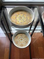 Two dishes on metal and glass shelving unit, top-down view