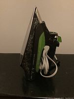 Side view of Rowenta Eco Intelligence steam iron showing water tank and cord wrapped around handle.
