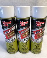 Three aerosol cans of Kleen-flo Glass Kleen with caution labels visible, showing packaging and brand.