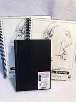 Three sketch books grouped together including one black hardcover book and two Robert Bateman Cover Series sketchbooks with drawings on front cover