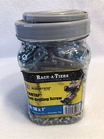 Jar of CAMTAP self-drilling screws with label visible showing size and quantity.