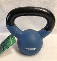 Front view of a new 10lbs blue fitness kettlebell with a black handle and an attached green tag showing it is a kettlebell.