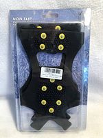 Packaged black rubber shoe cleats with yellow metal anti-slip studs for snow and ice.
