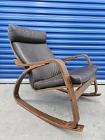Side view of bentwood frame rocking chair showing curved frame and padded leather cushions with headrest pillow