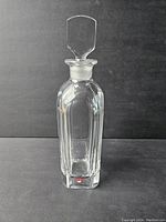 Front view of Orrefors crystal decanter with stopper showing clear crystal and faceted sides.