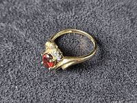 Side profile view showing twisted crossover band and gemstone setting