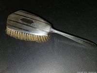 Angled view of the vintage sterling silver hairbrush showing bristles and handle