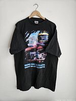 Front of black vintage Canada Grand Prix racing t-shirt with colorful graphic of race cars and race track text.