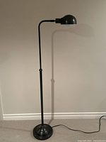 Full view of floor lamp at maximum height showing weighted base and dome shade
