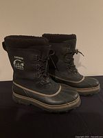 Pair of black Sorel Caribou waterproof men's boots shown from side angle on plain background.