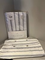 Photo showing Yves Delorme fitted sheet in sealed package with striped pattern and white background.