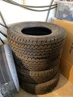 Four stacked tires leaning against wall