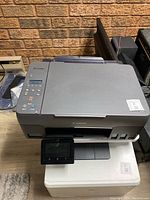 Front view of Canon PIXMA printer showing main body, control panel, and screen.