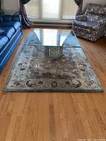Full view of wool area rug under glass coffee table showing color and overall pattern