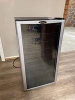 Front view of Danby beverage fridge showing tempered glass door and handle