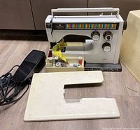 Sewing machine with extension table, tray of threads and hard case
