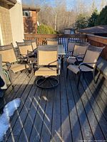 Overview of eight mesh sling chairs, two with swivel bases, and umbrella base ring on deck