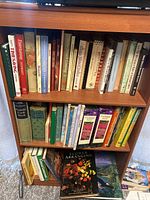 Photo of bookshelf filled with cookbooks, gardening, and flower arranging books