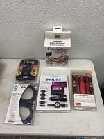 All items arranged on a small table showing all packages of the lot including Flexiview holder, Philips charger, Belkin cables, Eclipse timer and HDMI cable.