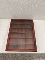 Full view of wooden shadow box display case showing rectangular shape, multiple internal compartments, and glass front panel.