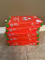 Side view of 5 stacked packs of Staples legal copy paper showing torn and worn packaging with clear product labeling