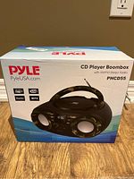 Front of the Pyle PHCD55 boombox package showing the product image and features like AUX, USB, MP3 support.