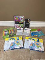Entire lot including coloring books, colored pencils, string art kits, and art therapy tags arranged on the floor.