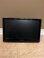 Front view of the Dynex flat screen TV with black bezel and screen off
