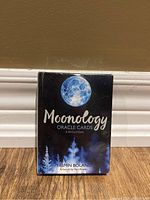 Front view of sealed Moonology Oracle Cards box showing moon artwork and title.