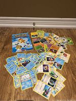 Photo showing a large assortment of Pokémon cards laid out on the floor, along with the Pokémon Sinnoh Region book.