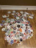 Wide view of a large pile of colorful stickers spread on the floor, showing the quantity and variety