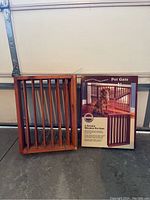 Photo showing one wooden pet gate panel standing upright next to the product box featuring dog image and product name.